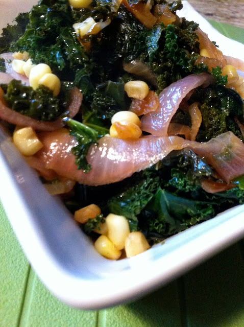 Bowl of sautéed kale with corn kernels and caramelized onions, dark green and yellow tones